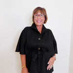 Woman wearing a black coat with a white background