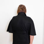 Person wearing a black jacket against a white background