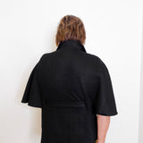 Person wearing a black jacket against a white background