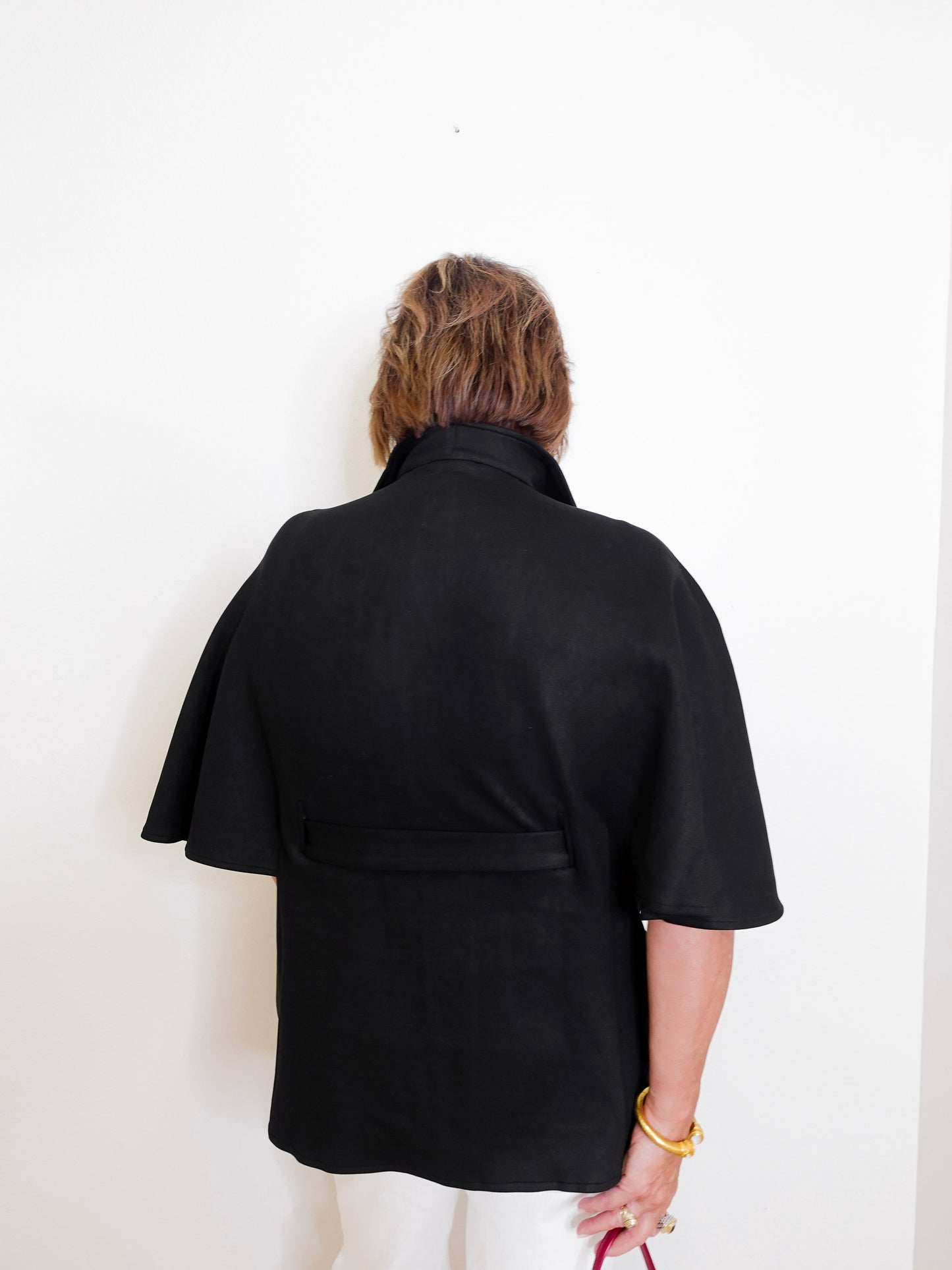 Person wearing a black jacket against a white background
