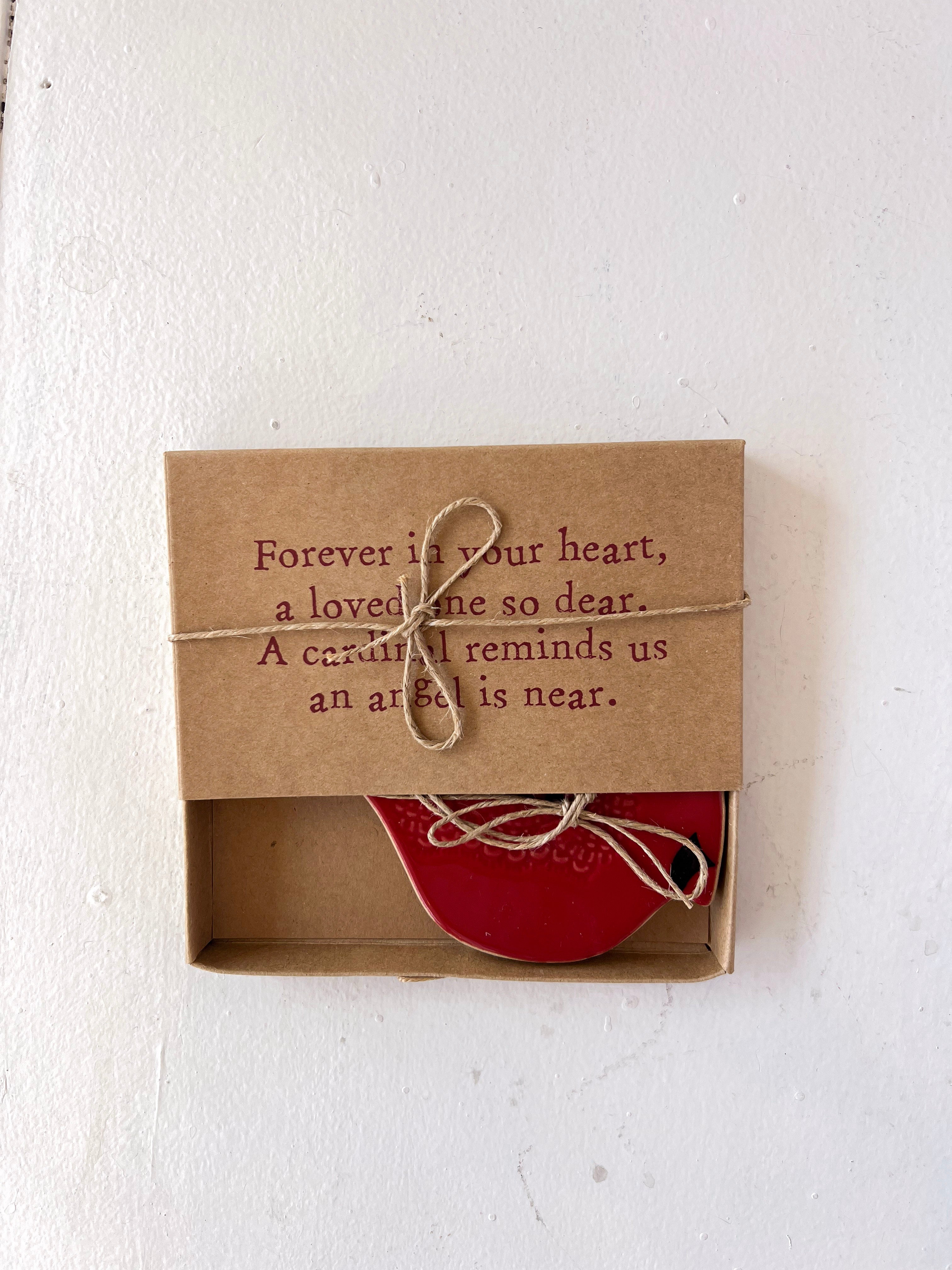 Red heart-shaped object in a brown box with a sentimental message on a white background