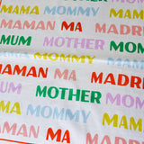 Textual fabric with 'MUM', 'MOTHER', 'MAMA', 'Mommy', 'MAMAN', 'MA', 'MADRE' in various colors on a white background.