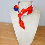 Colorful scarf on a mannequin head against a plain background