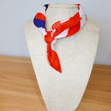 Colorful scarf on a mannequin head against a plain background