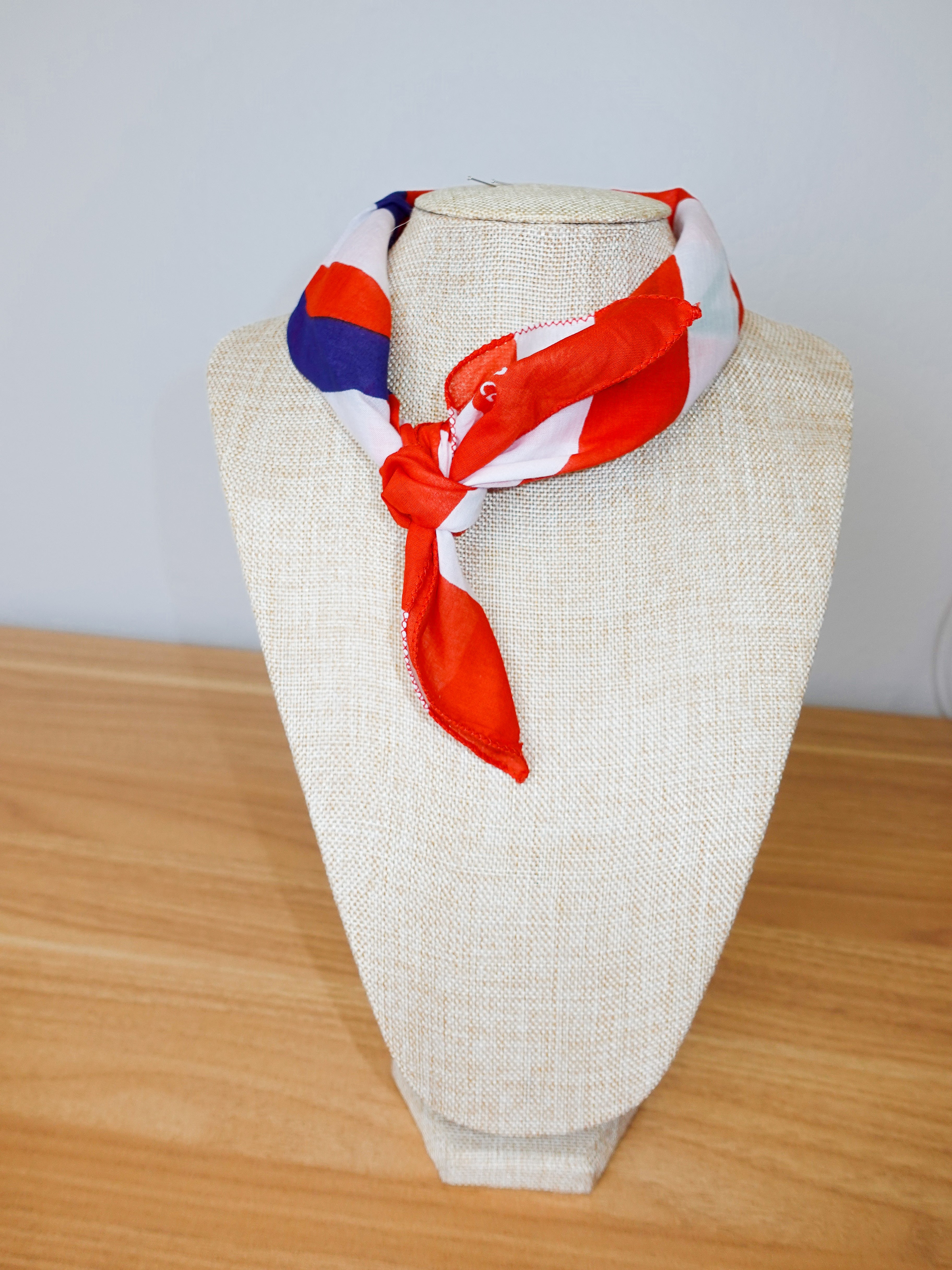 Colorful scarf on a mannequin head against a plain background