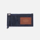Navy blue cardholder with a brown leather patch on a light gray background
