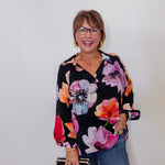 Woman wearing a floral blouse with a plain background