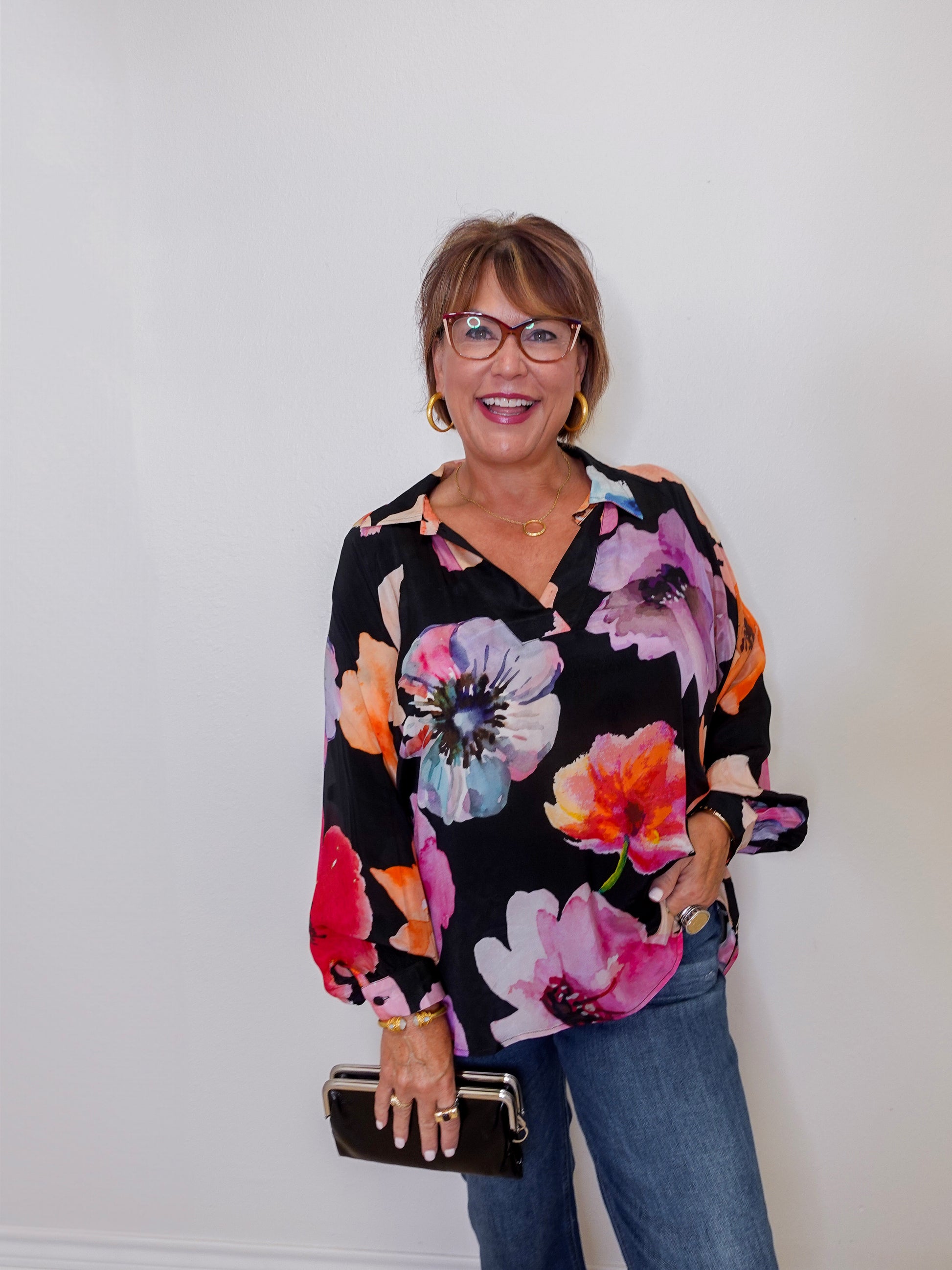 Woman wearing a floral blouse with a plain background