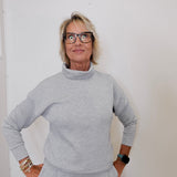 Person wearing a gray outfit against a white background