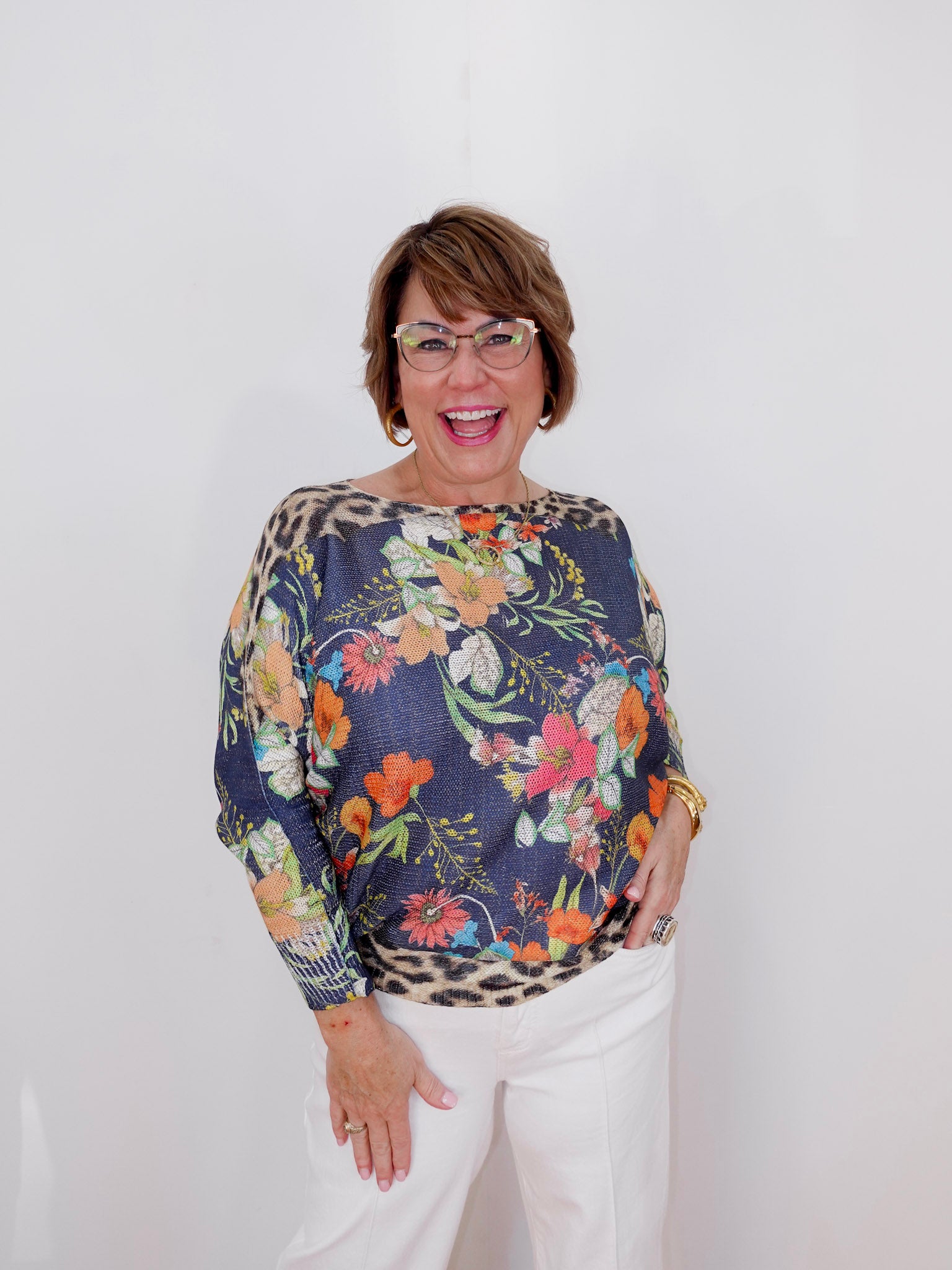 Woman wearing a floral blouse with a leopard print pattern on a white background