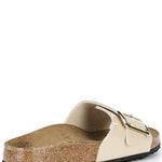 Beige sandal with a gold buckle on a white background