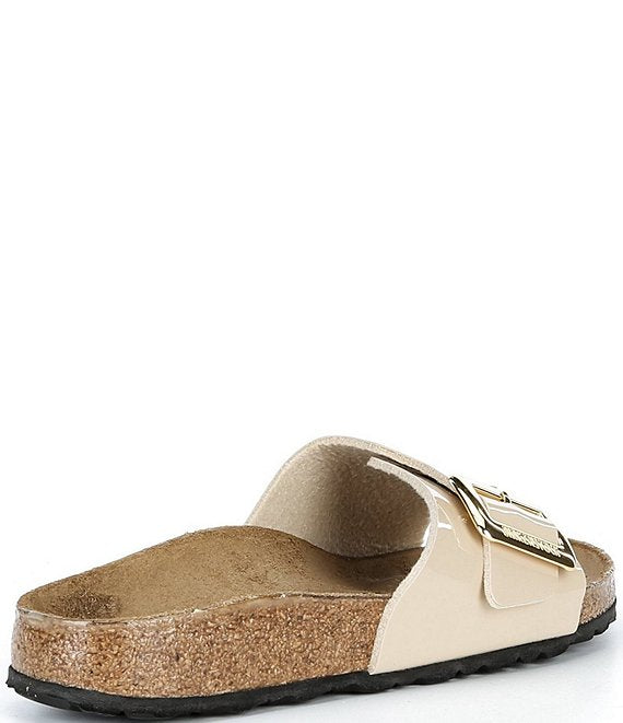 Beige sandal with a gold buckle on a white background