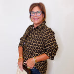 Woman wearing a chain print blouse with a plain background