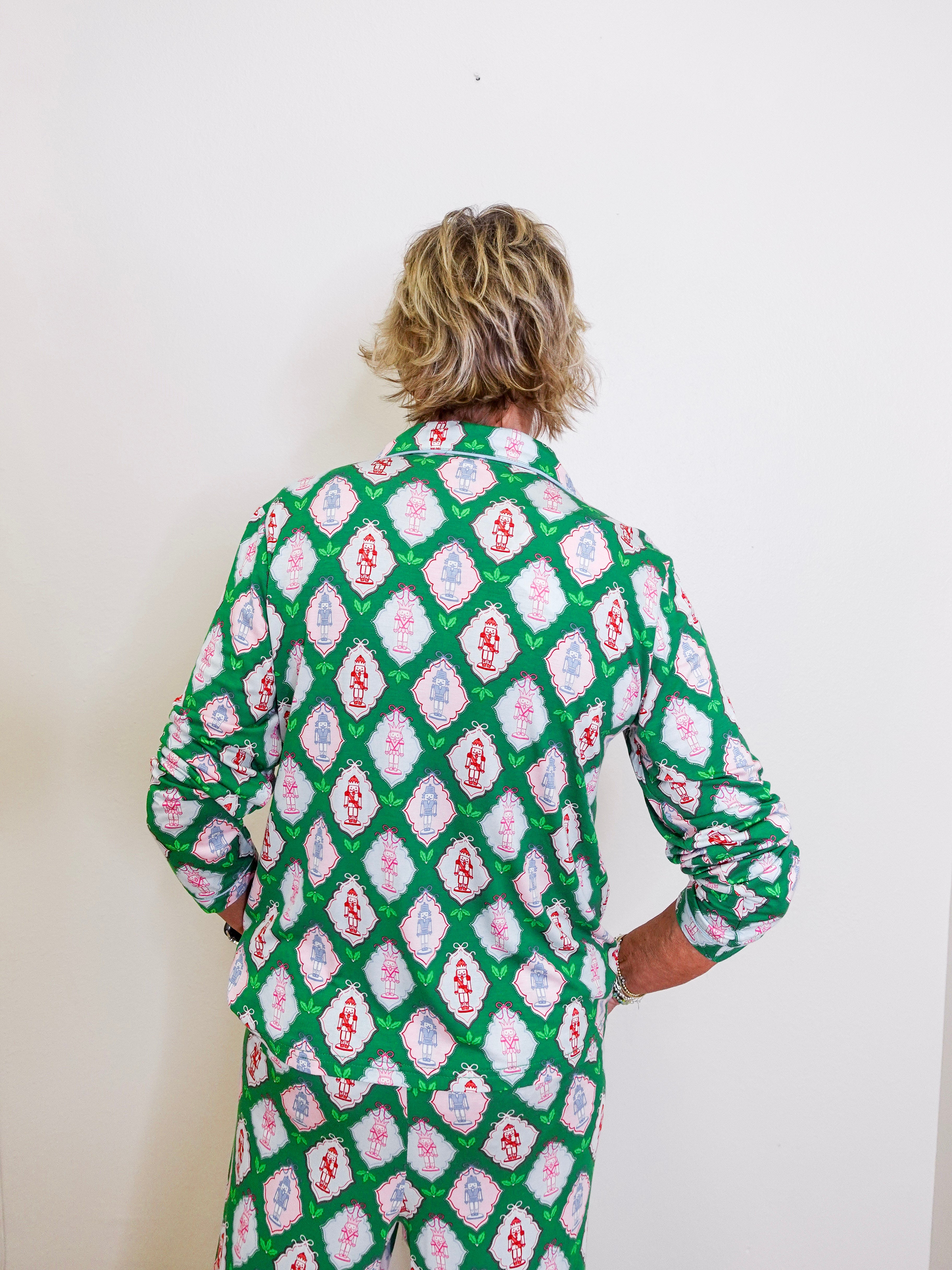 Person wearing a green patterned shirt against a white background