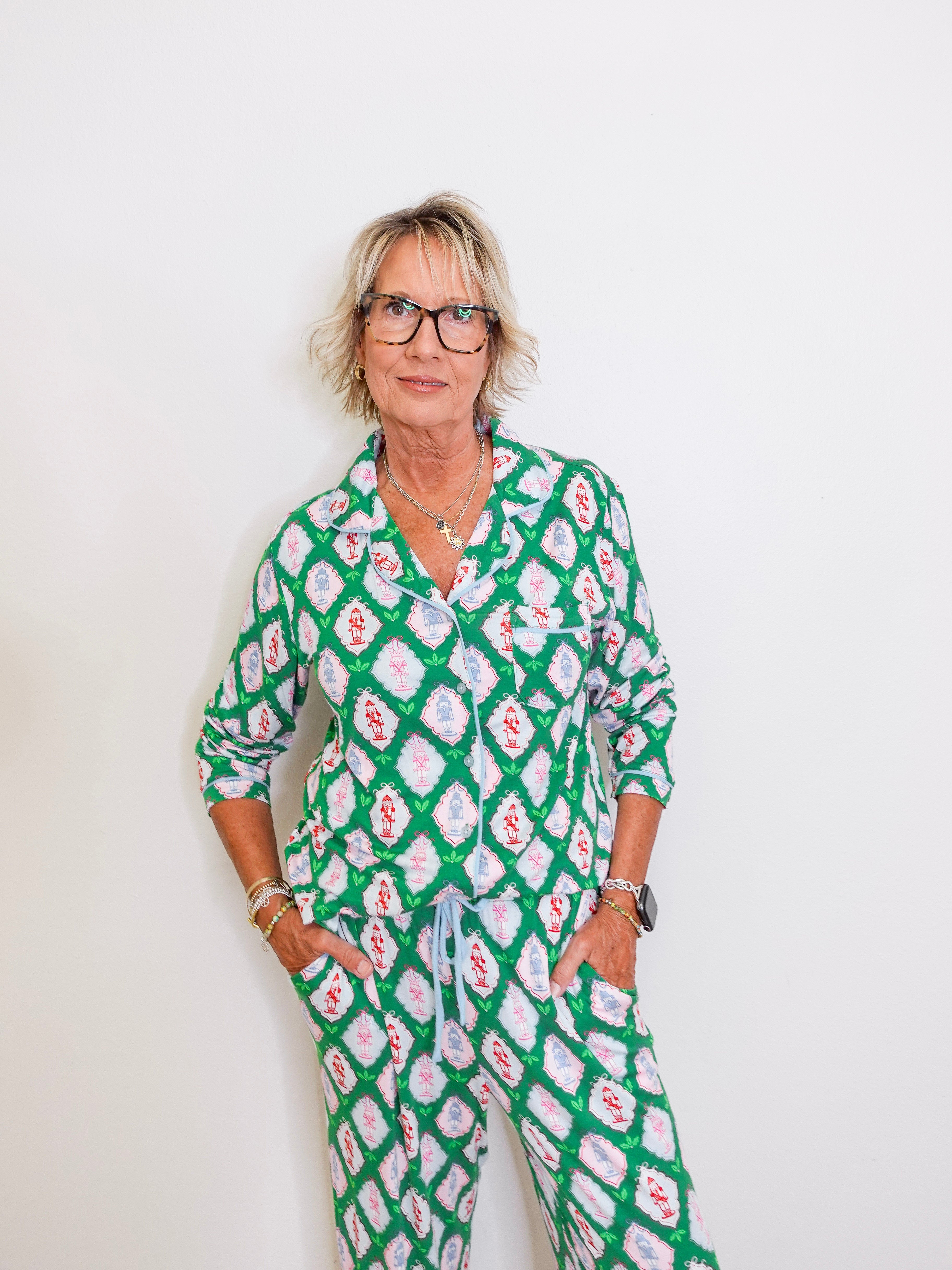 Woman wearing a green patterned outfit against a white background