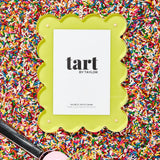 Green picture frame with 'tart by Taylor' branding on a colorful sprinkles background
