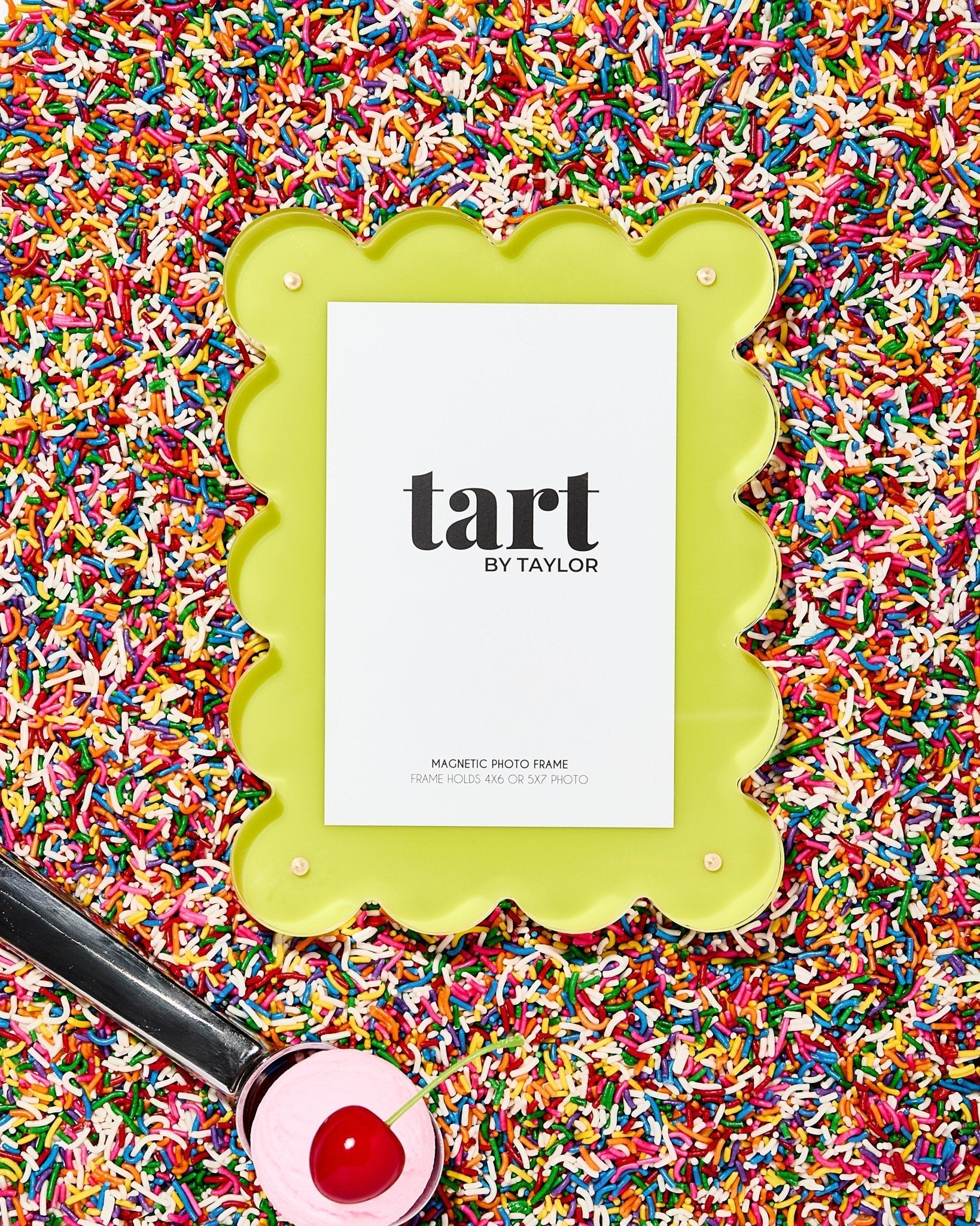 Green picture frame with 'tart by Taylor' branding on a colorful sprinkles background