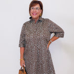 Woman wearing a leopard print dress with a plain background