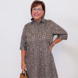 Woman wearing a leopard print dress with a plain background