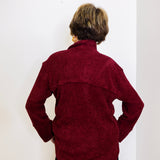 Person wearing a maroon sweater against a white background