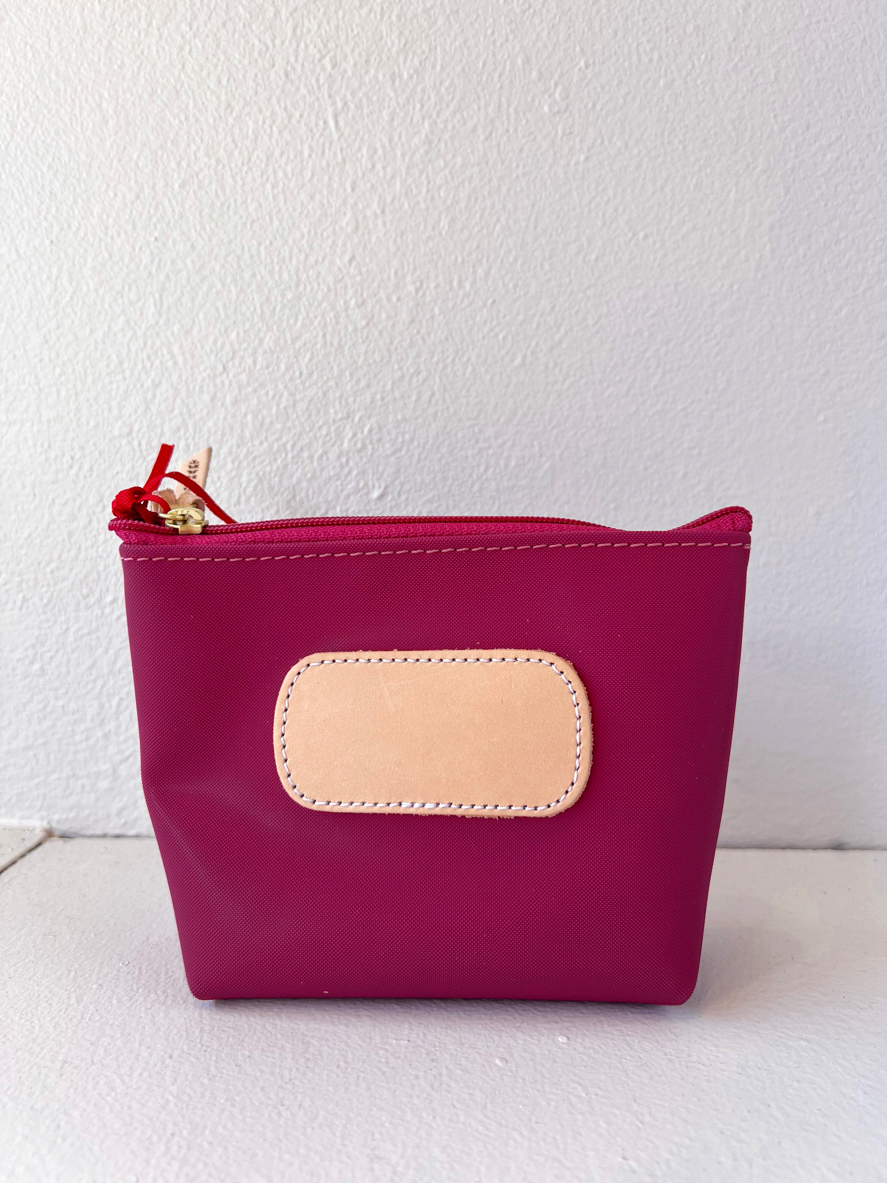 Pink pouch with a beige patch on a white background
