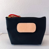 Black pouch with a beige patch on a white background