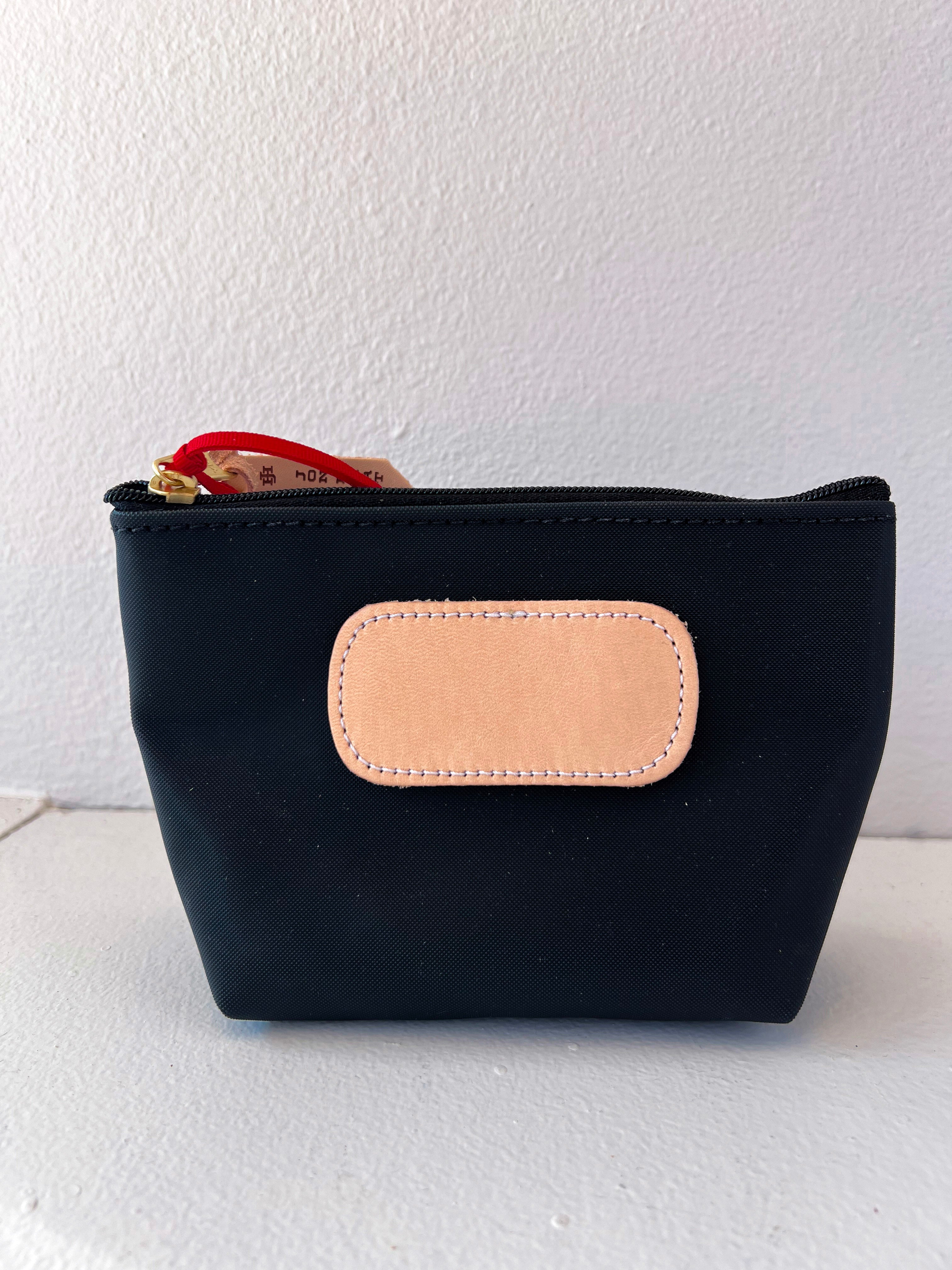 Black pouch with a beige patch on a white background