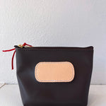 Black pouch with a beige patch and red zipper on a white background