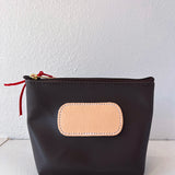 Black pouch with a beige patch and red zipper on a white background