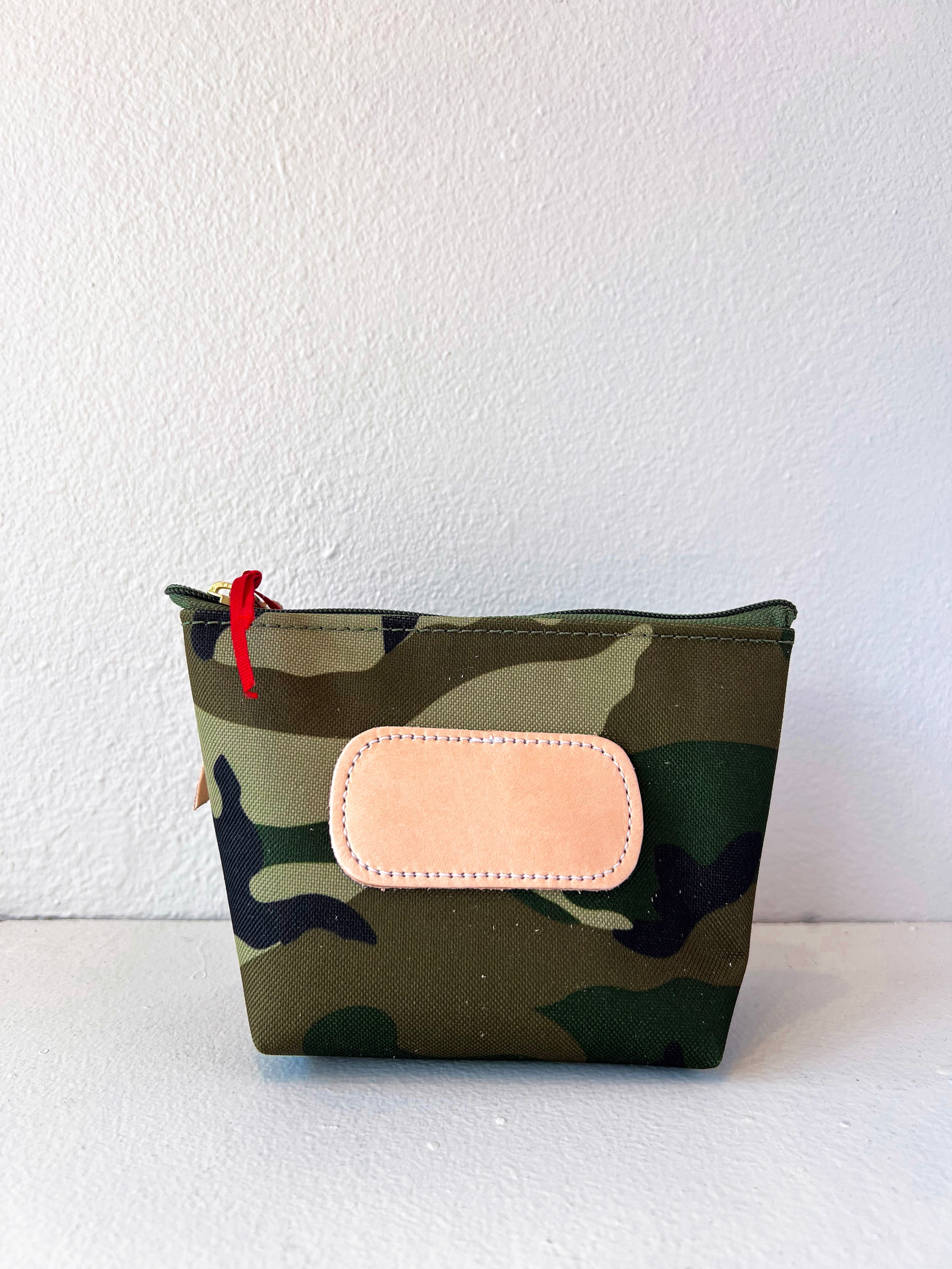 Camouflage pouch with a pink patch on a white background