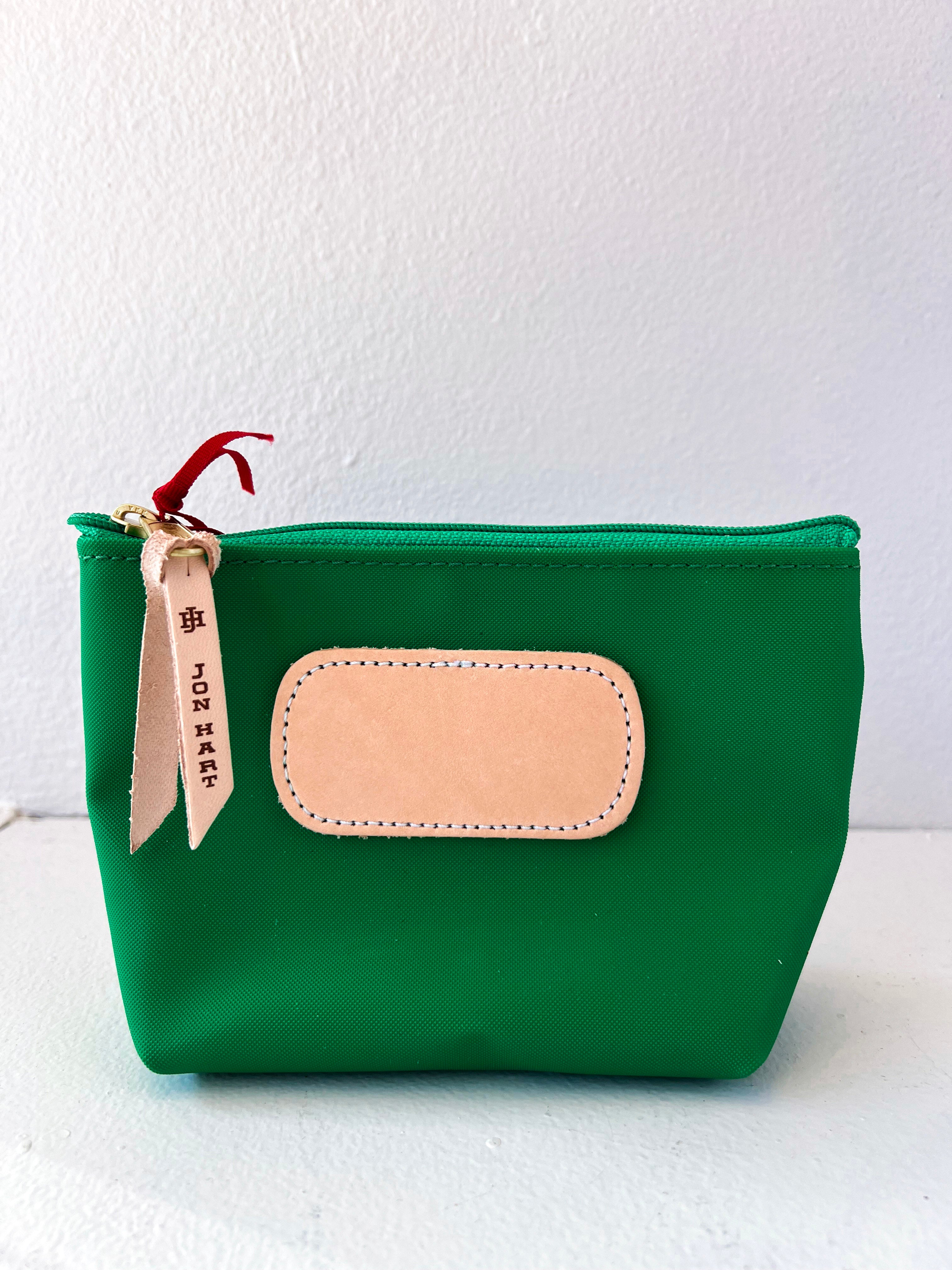 Green pouch with beige patch and red zipper pull on a white background