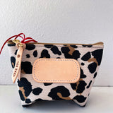 Leopard print pouch with beige flap and strap on a white background