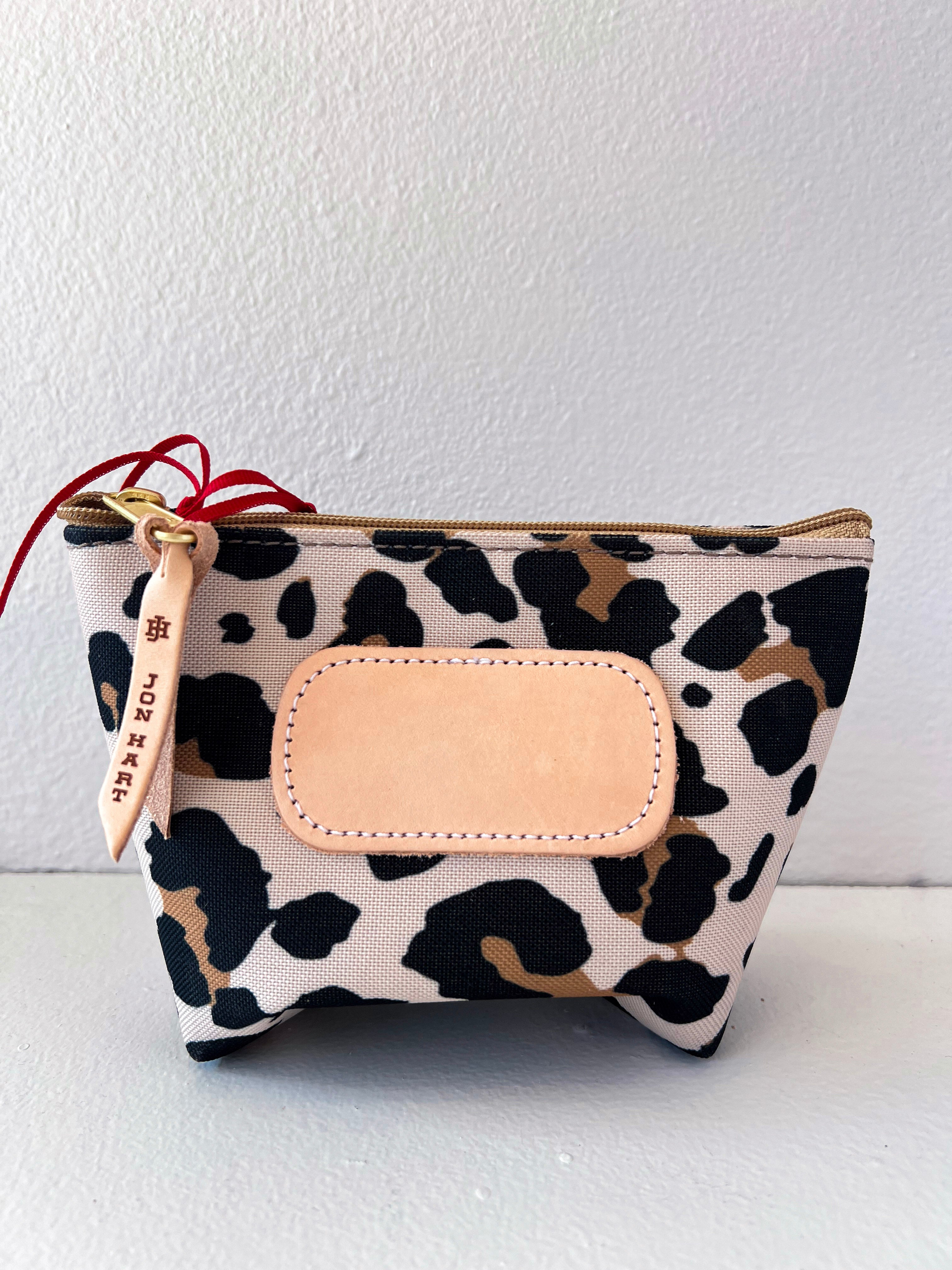 Leopard print pouch with beige flap and strap on a white background