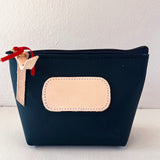 Navy blue pouch with beige patch and red zipper pull on a white background