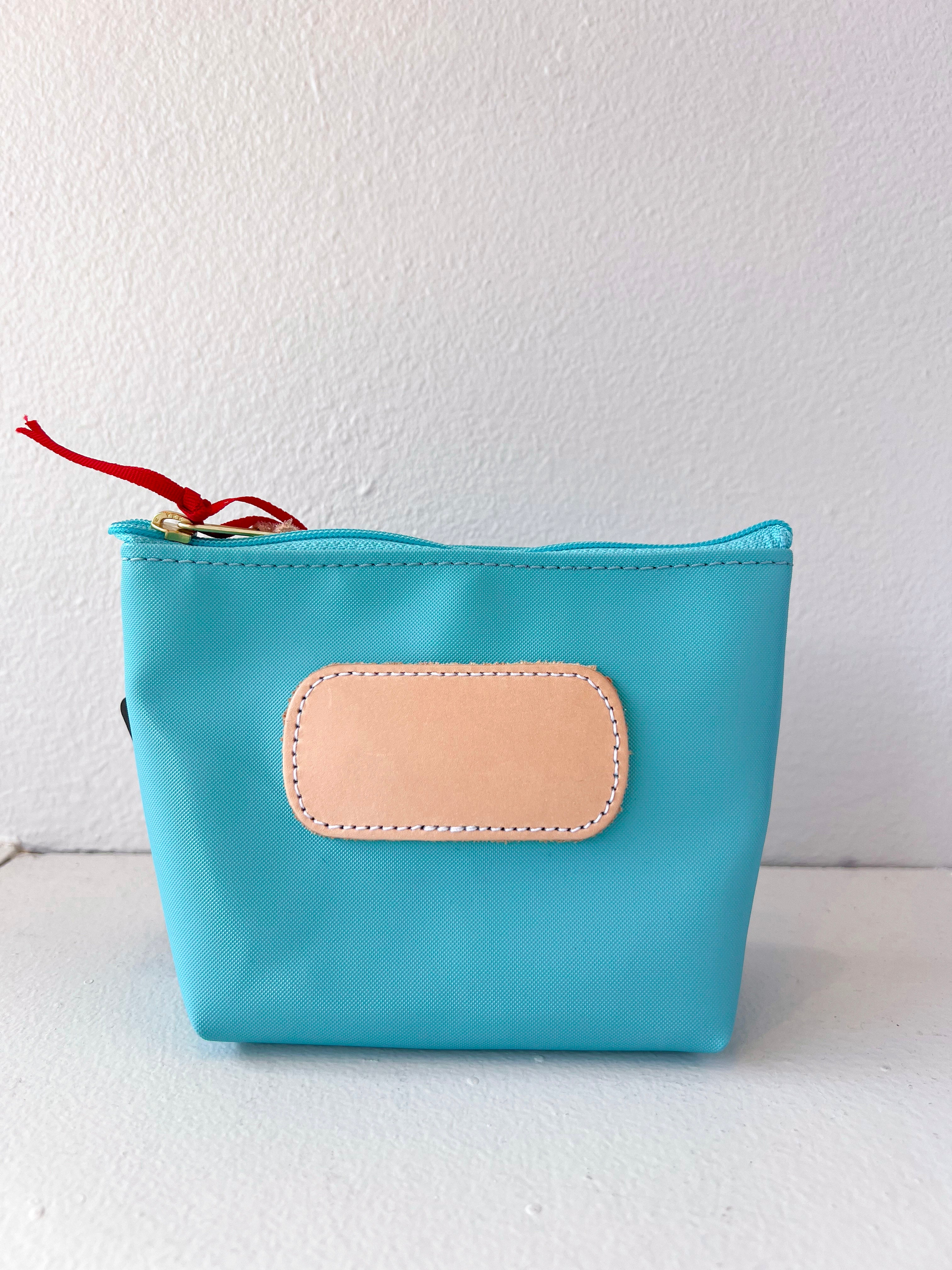 Blue pouch with a beige patch on a white background