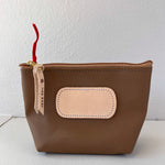 Brown pouch with beige patch and red string on a white background