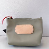 Gray pouch with a beige patch and red zipper pull on a white background