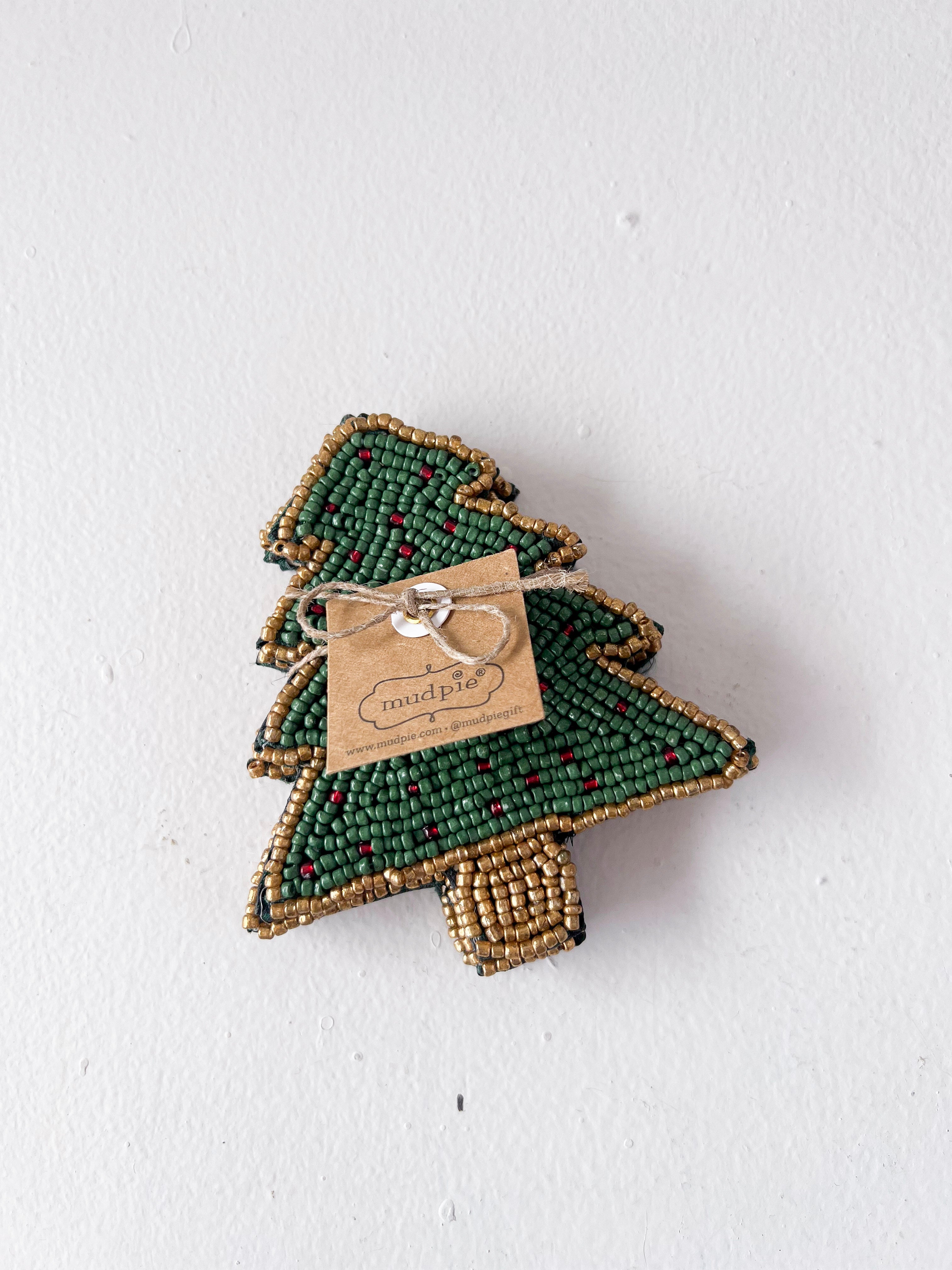 Green beaded tree-shaped ornament with a tag on a white background