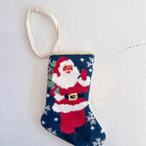 Small needlepoint Christmas stocking with Santa Claus on a white background
