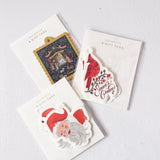 Three packages of Christmas-themed gift tags on a white background
