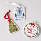 Three Christmas-themed ceramic ornaments on a light gray background