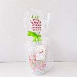 Clear plastic bag with floral design and greenery on a white background