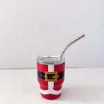Red tumbler with Santa Claus design and metal straw on a white background