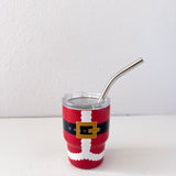 Red tumbler with Santa Claus design and metal straw on a white background
