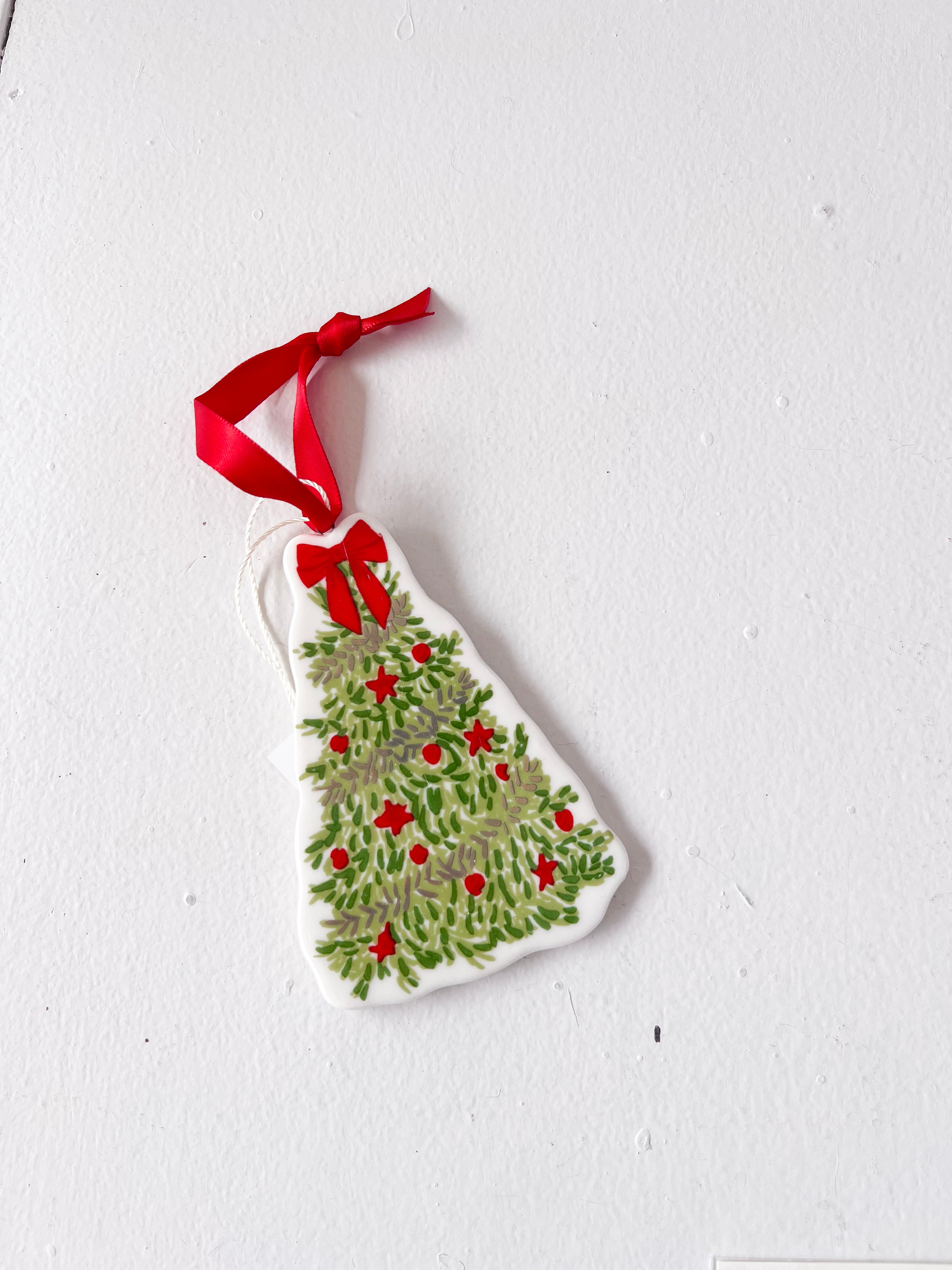 Christmas tree ornament with red berries and a red ribbon on a white background