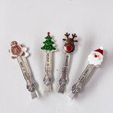 Four Christmas-themed spoons with decorative ends on a light gray background