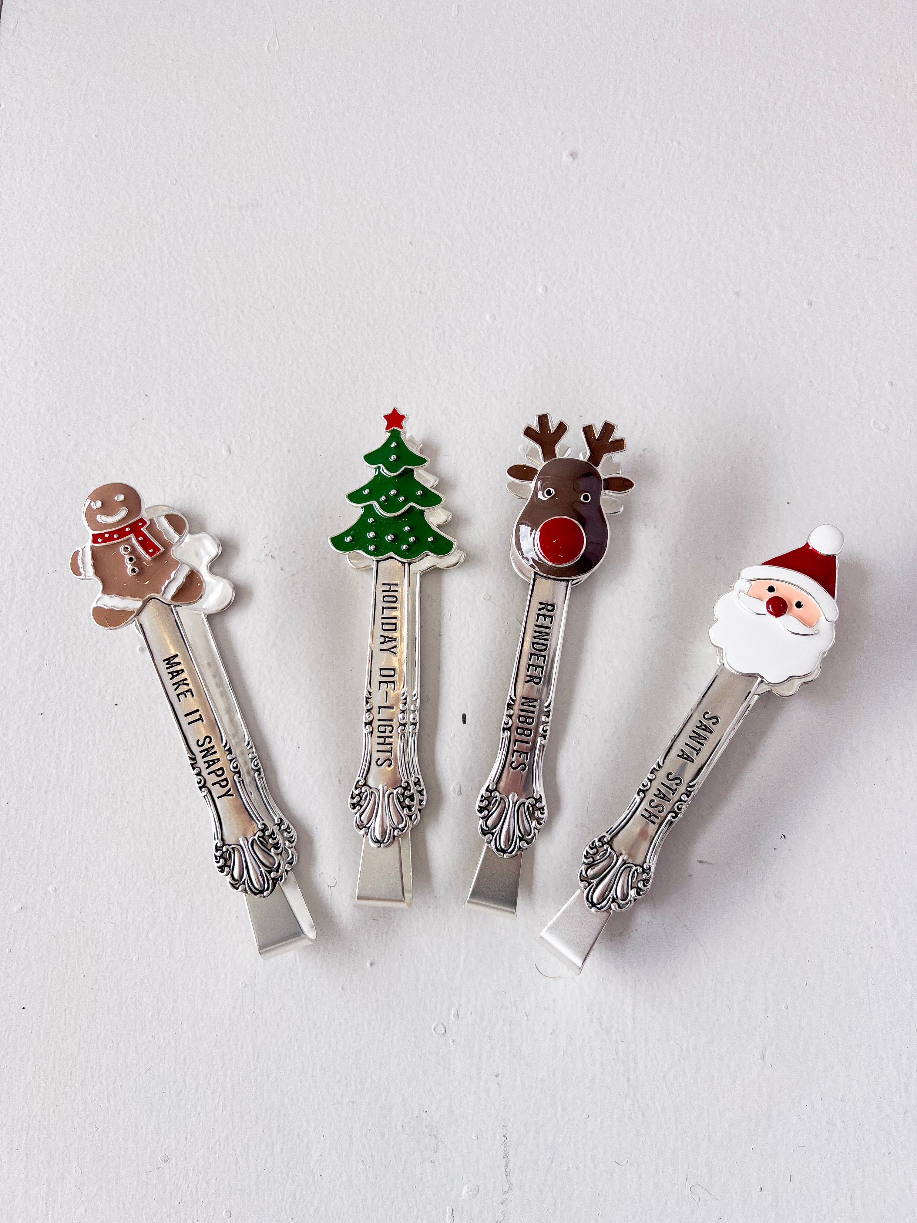 Four Christmas-themed spoons with decorative ends on a light gray background