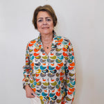 Woman wearing a colorful patterned shirt against a plain background