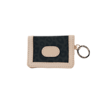 Small beige wallet with a keychain on a black background