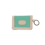 Small green and beige wallet with a key ring on a white background